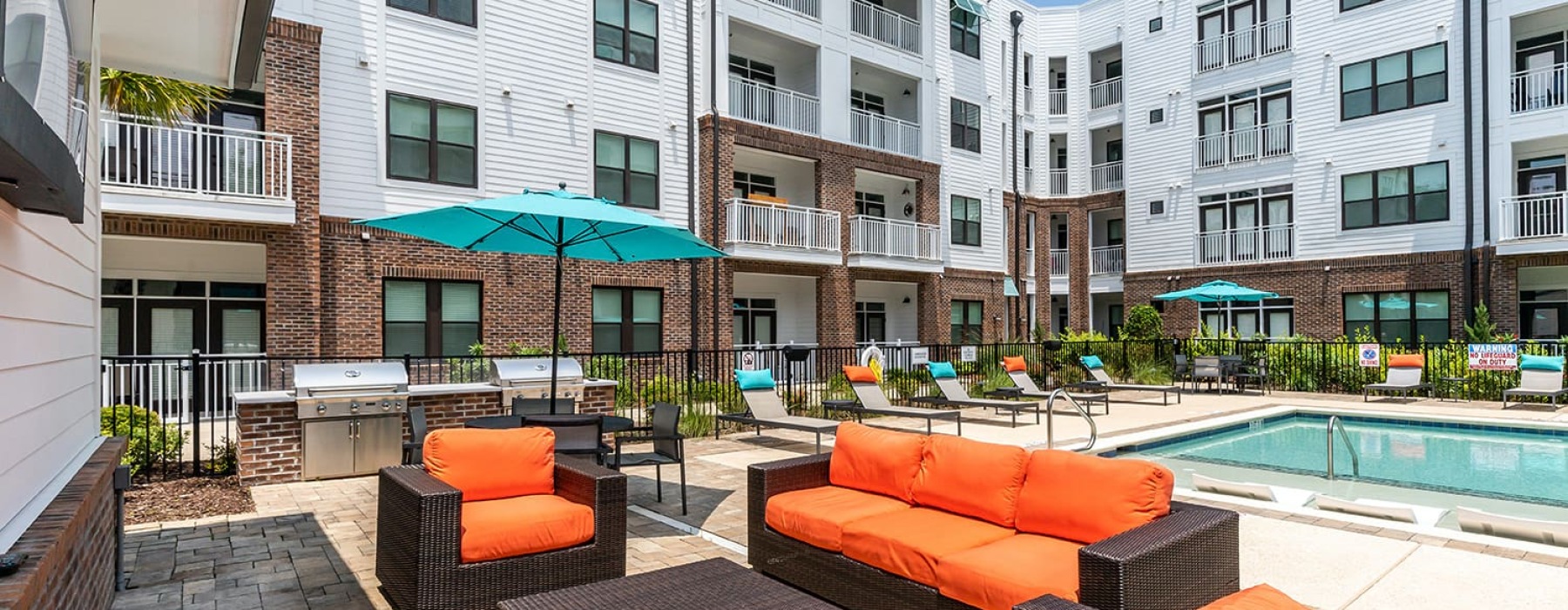 Poolside seating and grilling station enclosed by apartment unit